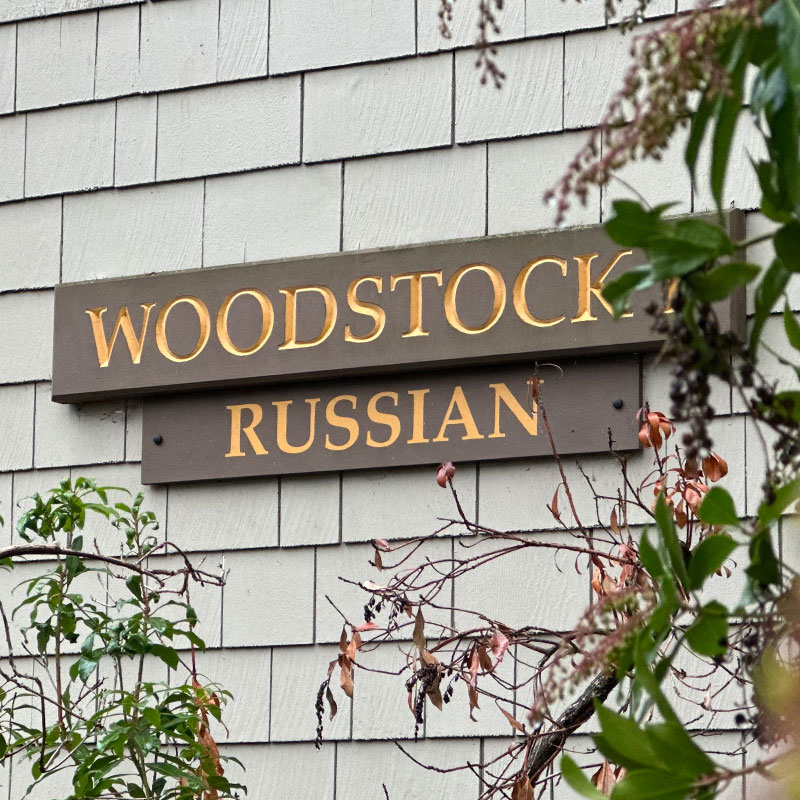A brown sign on Reed's Russian House with yellow letters that read "Woodstock" and "Russian."
